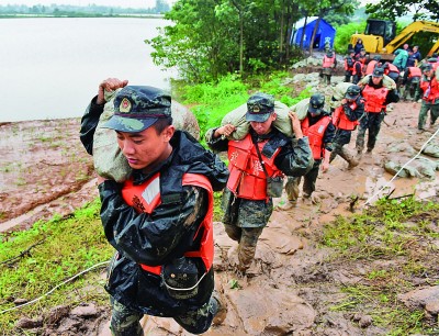安徽省安庆市：皖江大堤上，鲜红的旗帜在风雨中飘扬